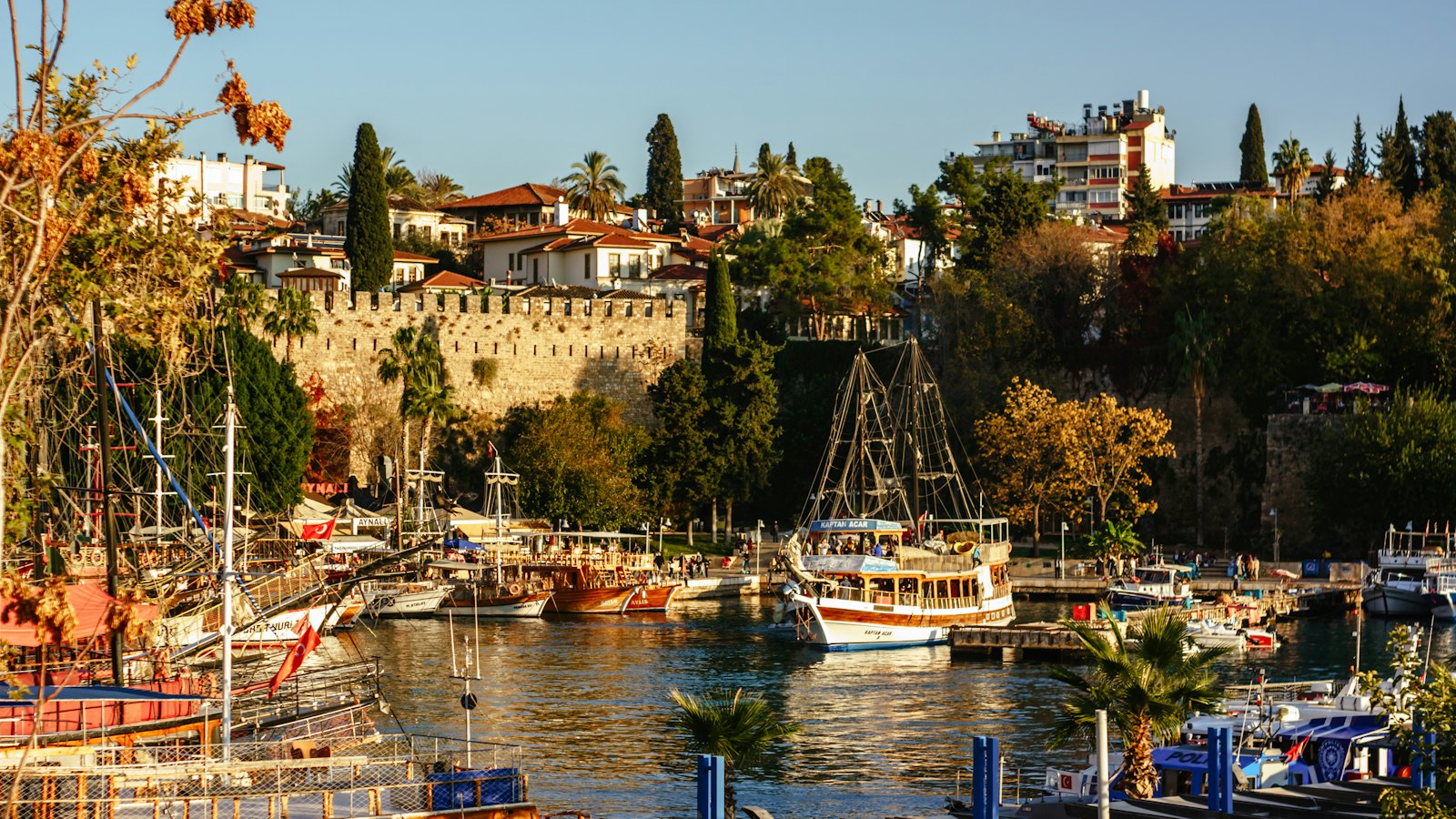 Old town walls and harbor boats of Kaleici in Antalya at golden hour