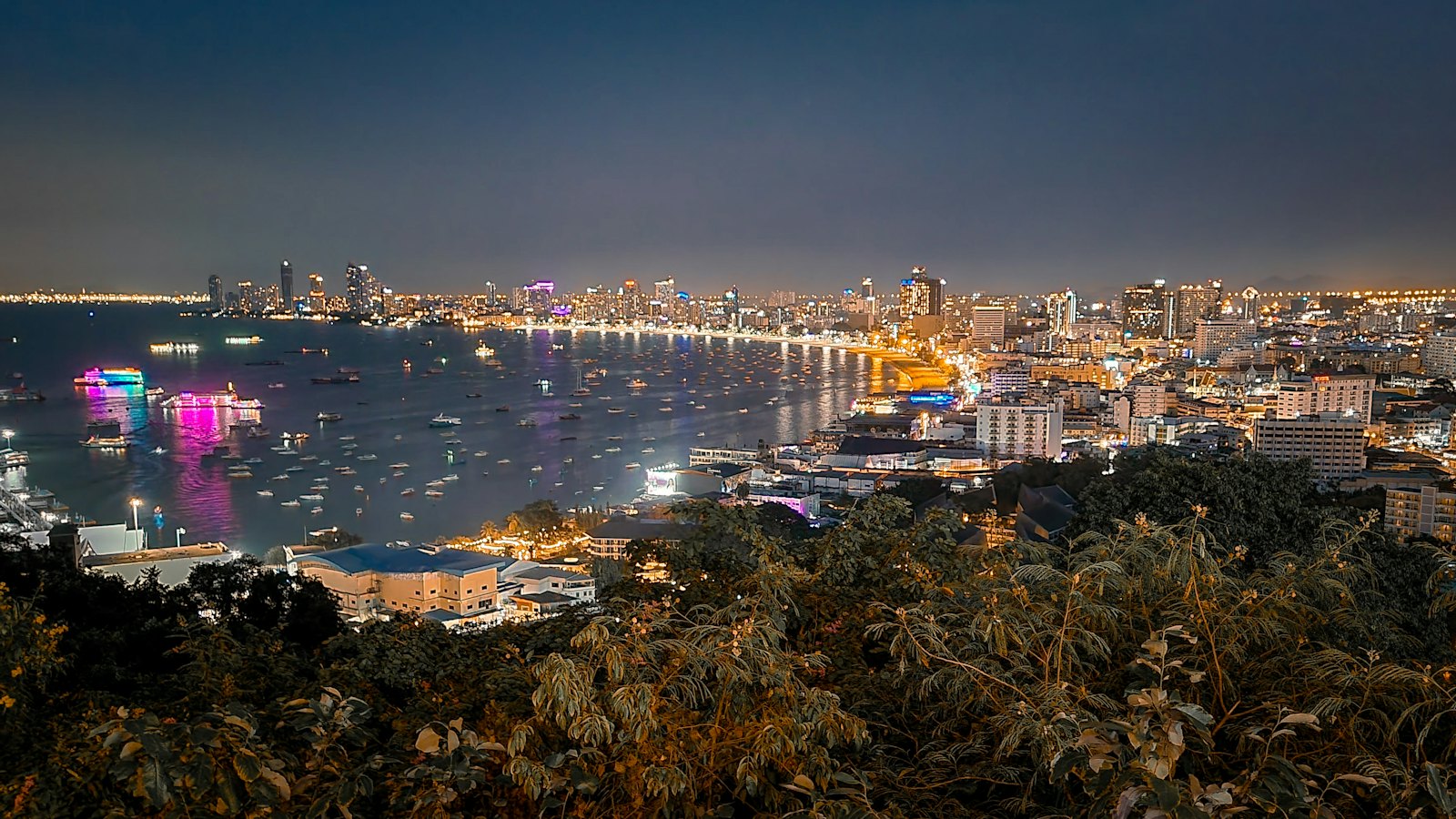 Pattaya Bay's skyline and harbor lights seen from Phra Tamnak viewpoint at night