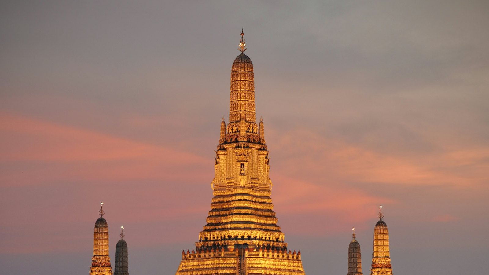 Wat Arun lit at sunset on the Chao Phraya, Bangkok
