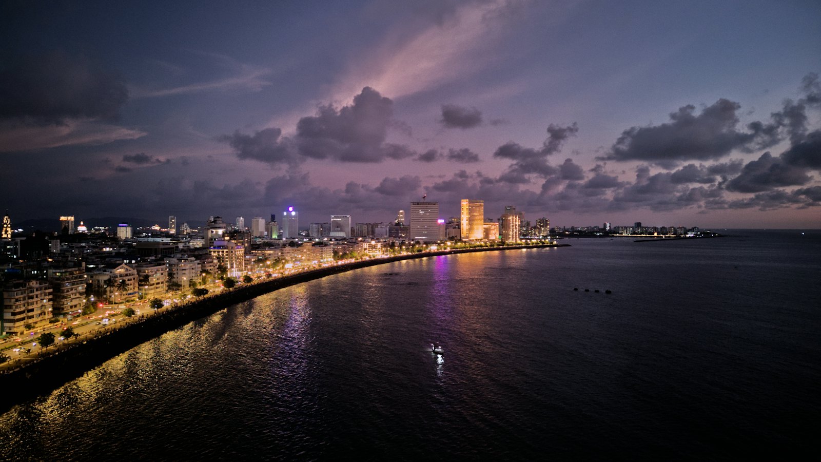 Marine Drive curving along the Arabian Sea at dusk beneath purple clouds, Mumbai