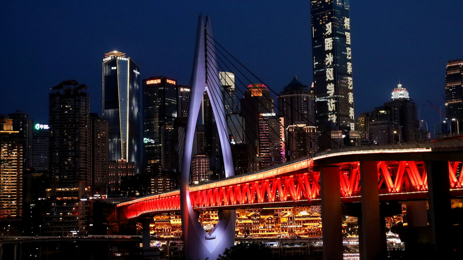 Qiansimen Bridge glowing red at blue hour above Hongyadong and the Chongqing skyline