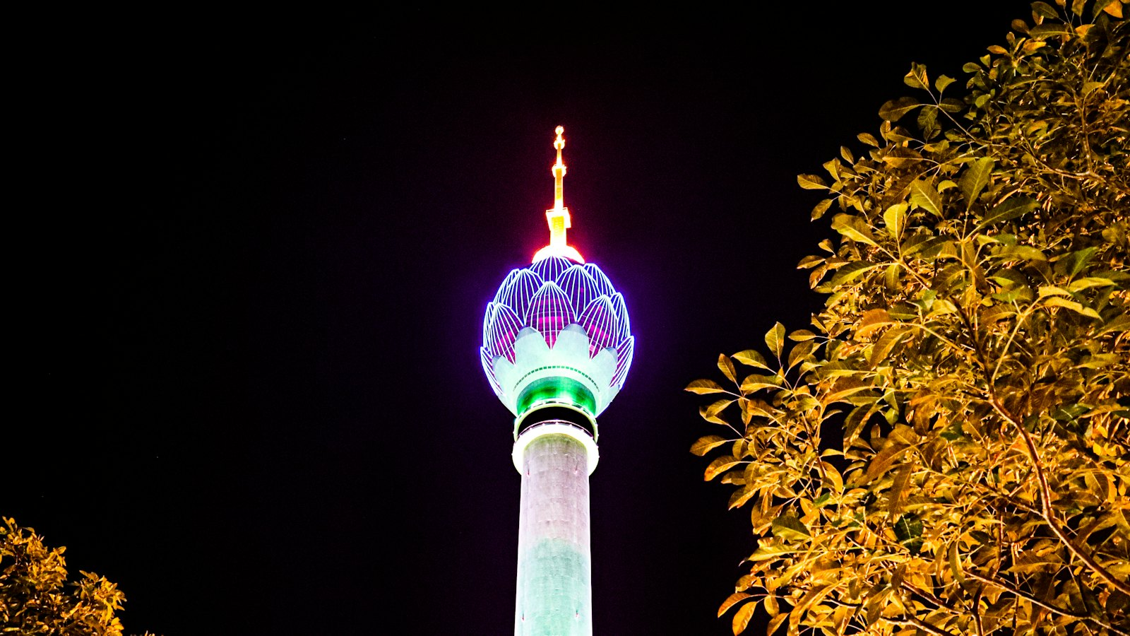 Colombo's Lotus Tower glowing purple and green against the night sky, Sri Lanka