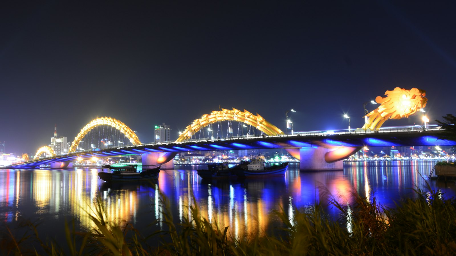 Dragon Bridge glowing gold and blue over the Han River in Da Nang at night