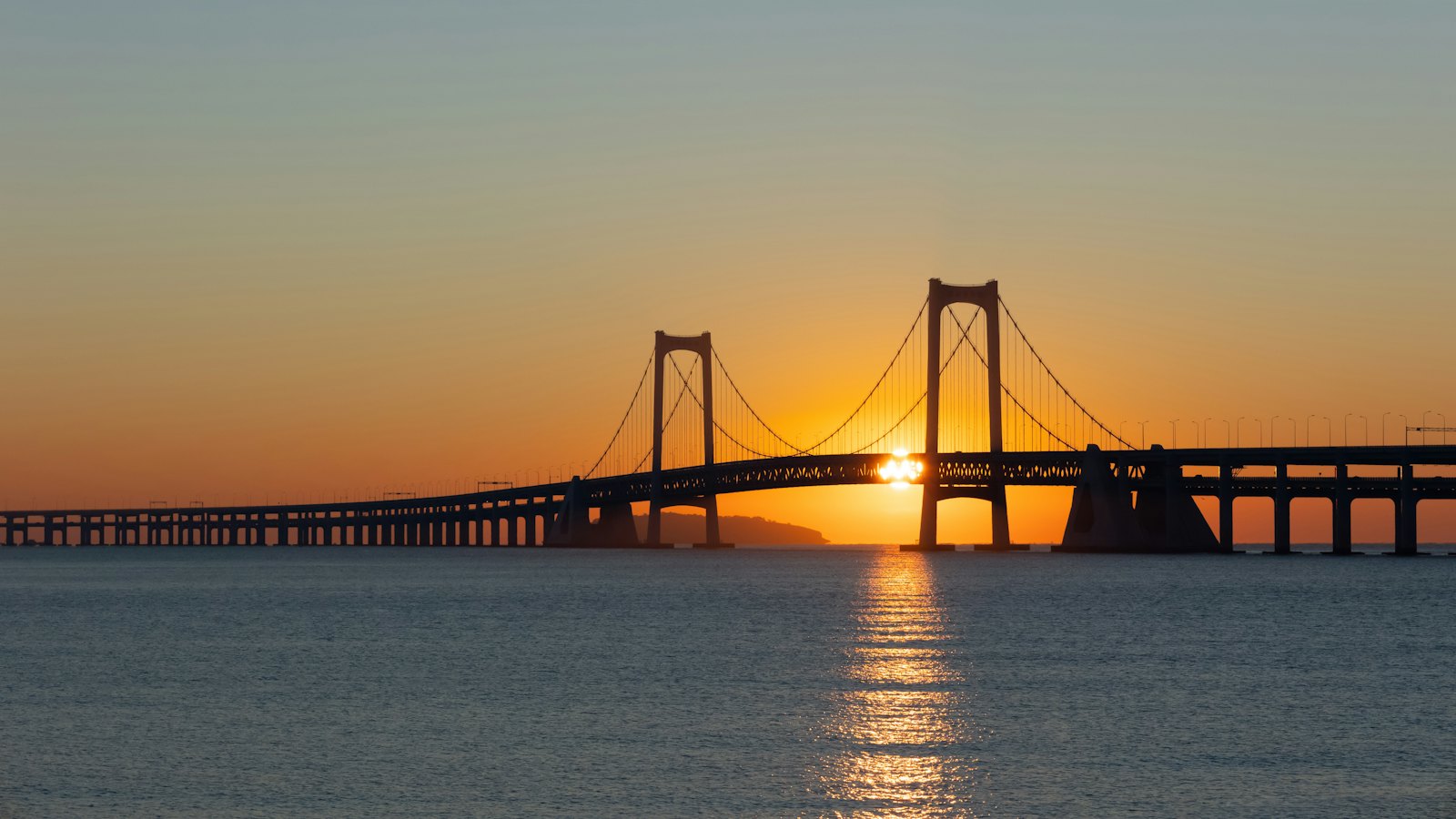 Sunset silhouette of the Xinghai Bay cross-sea suspension bridge in Dalian