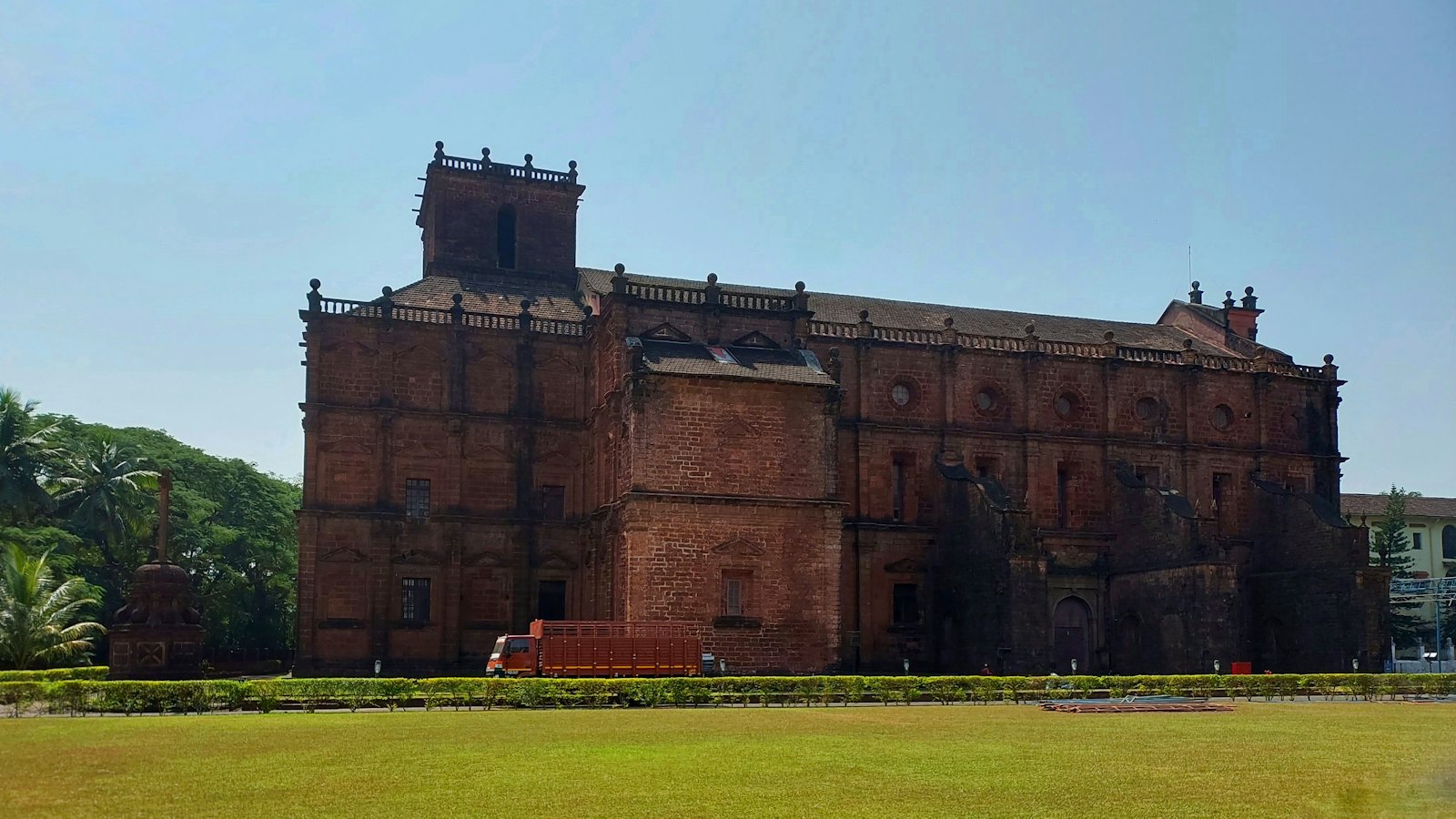 The reddish laterite facade and bell tower of the Basilica of Bom Jesus in Old Goa