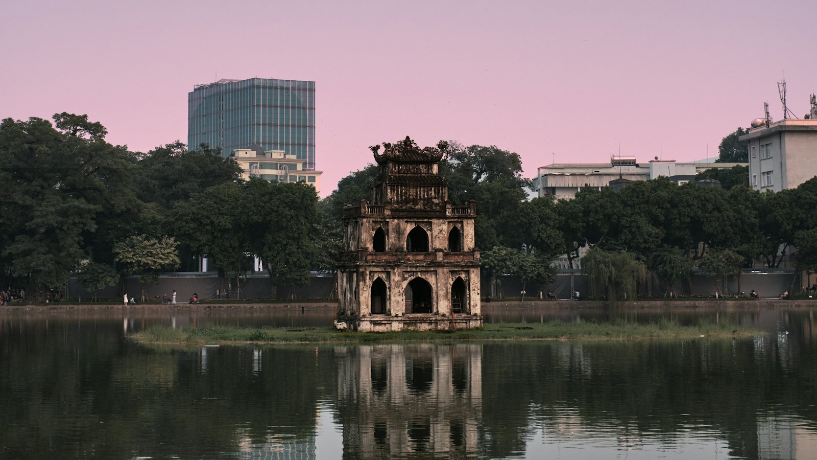 Turtle Tower on its island in Hoan Kiem Lake, Hanoi, at dusk under a pink sky