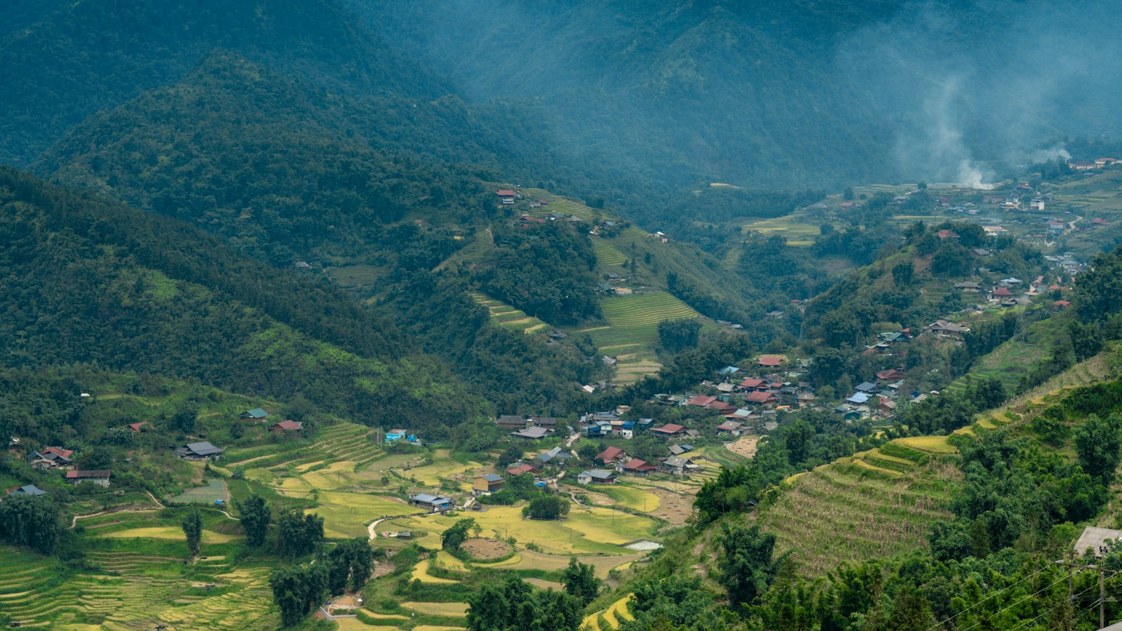 Misty terraced rice fields and a village in Sapa's mountain valley