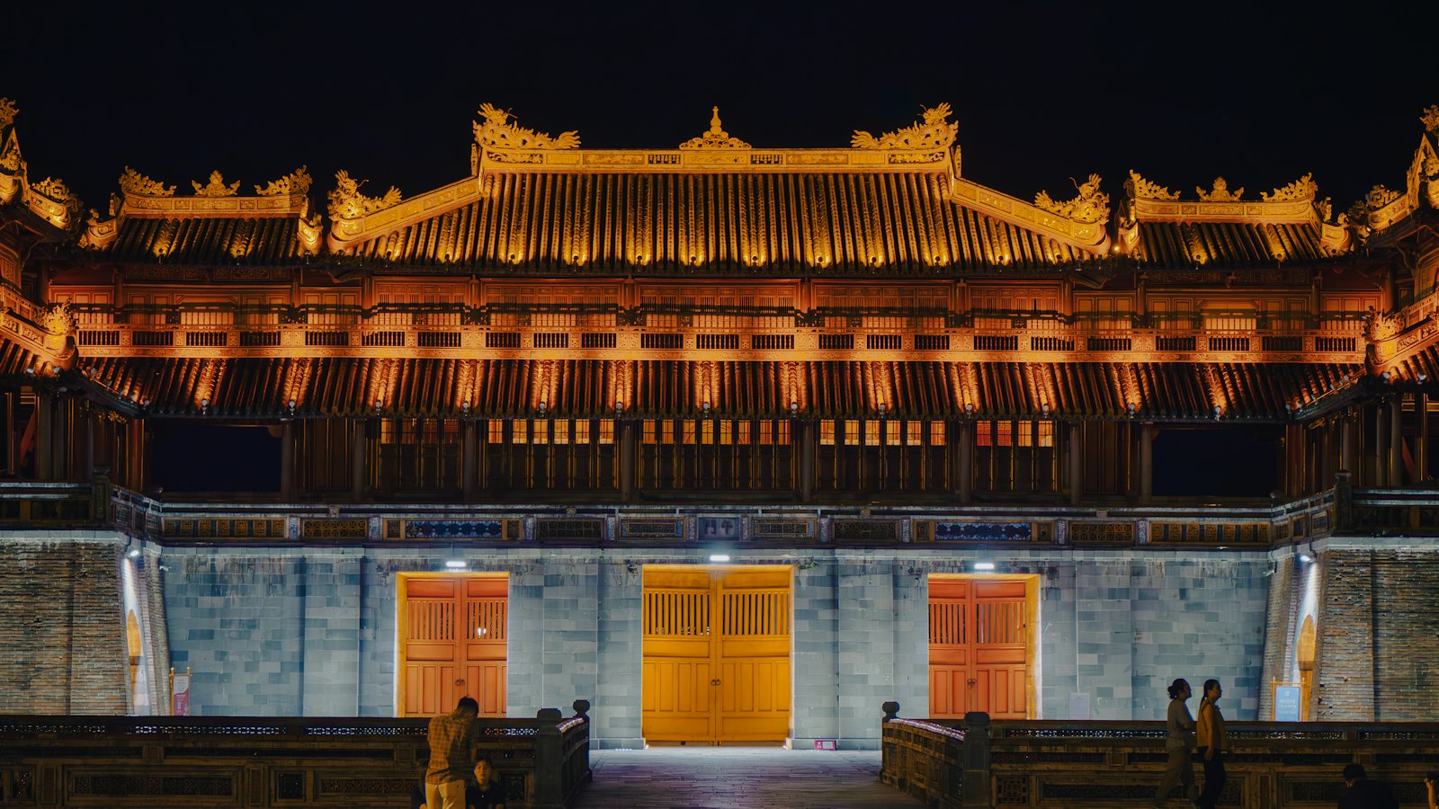 A golden-lit palace hall glowing at night inside Hue's Imperial Citadel