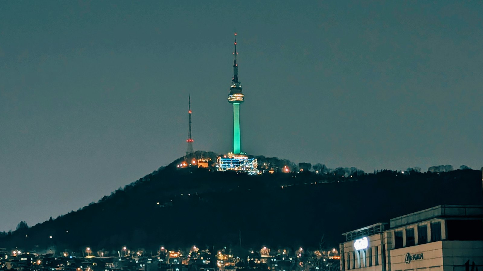 N Seoul Tower lit up on Namsan above a Seoul street at night