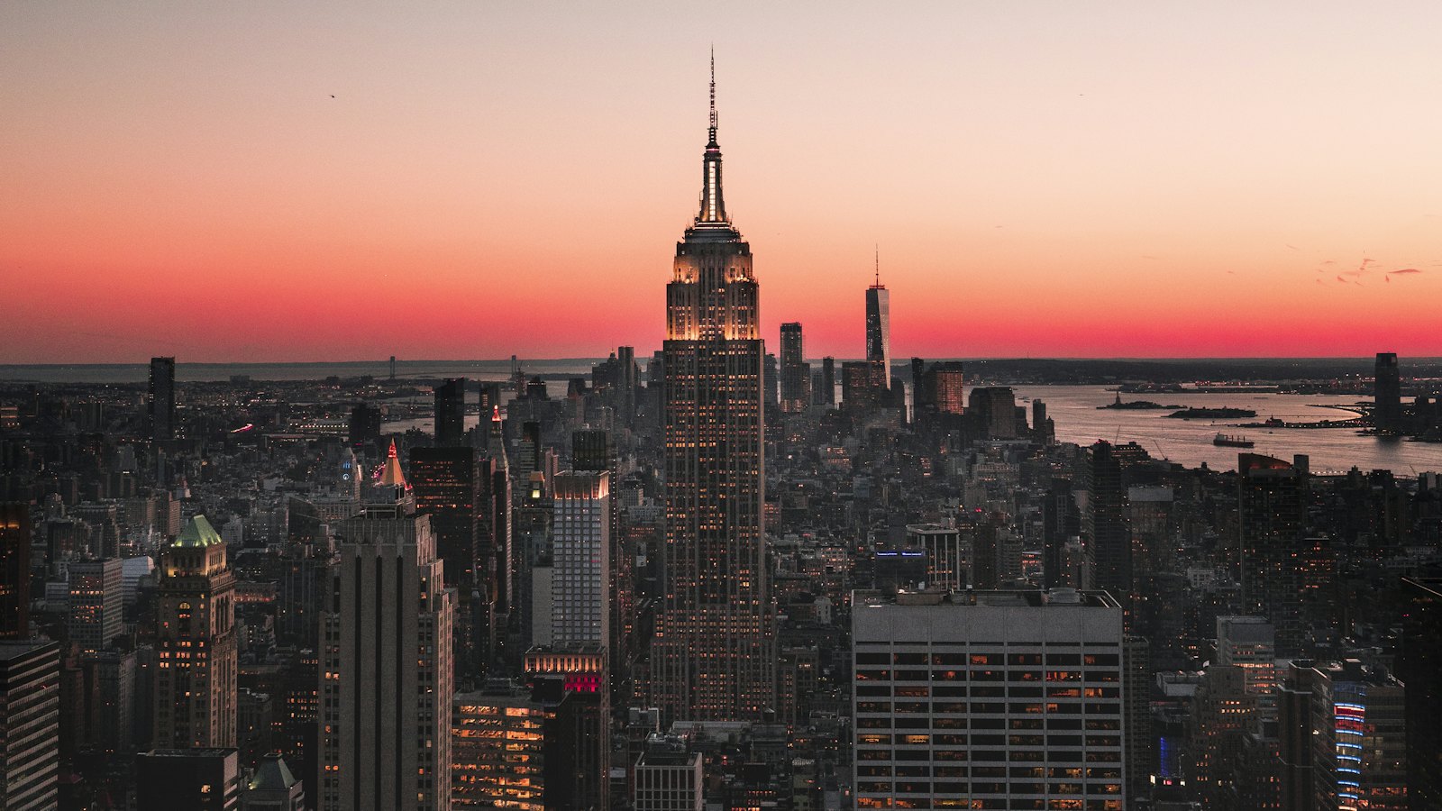 The Empire State Building glowing above the Manhattan skyline at dusk, seen from Top of the Rock, New York