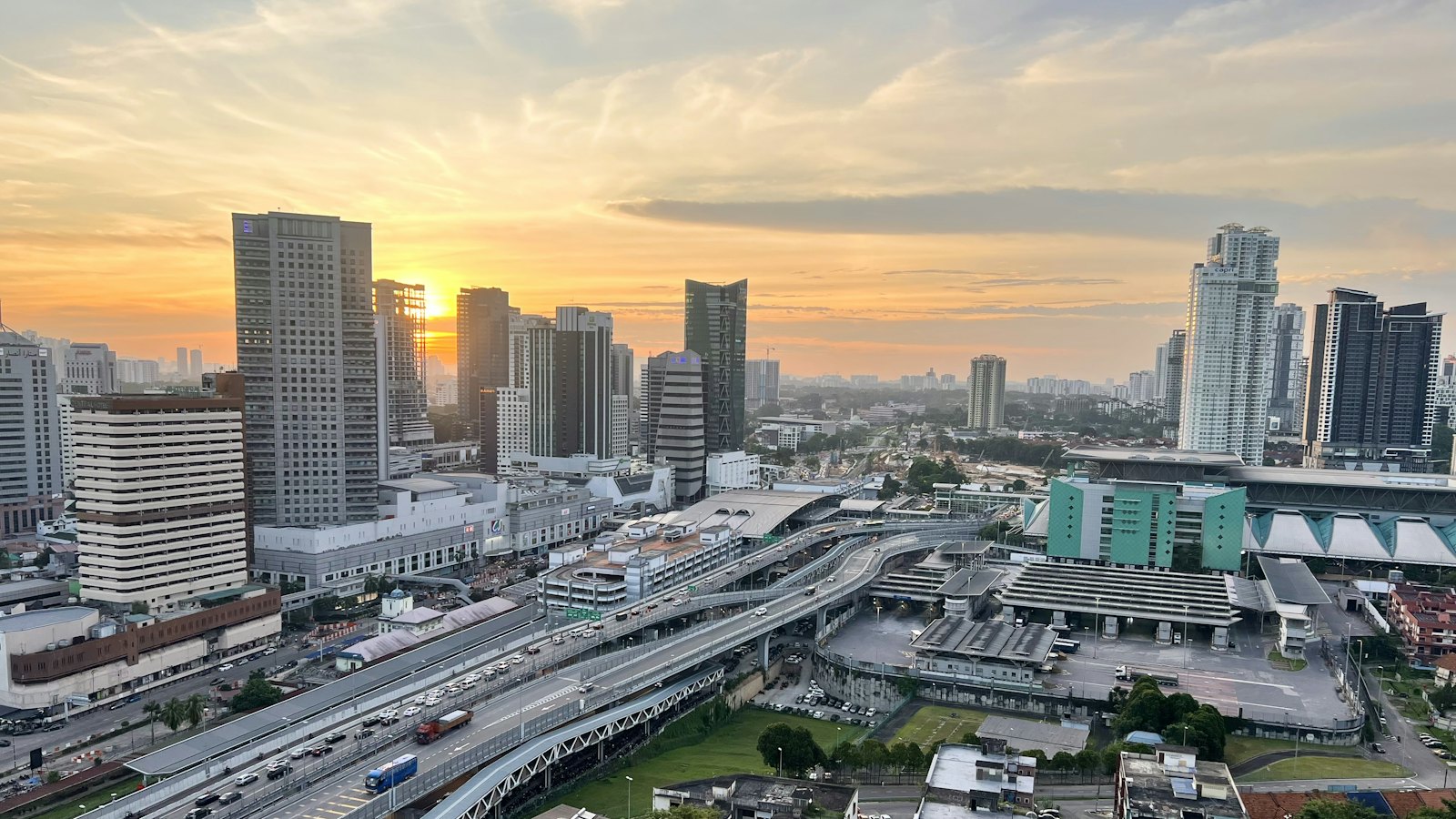 Sunset over the Johor Bahru city skyline and the elevated Causeway approach beside the CIQ border complex