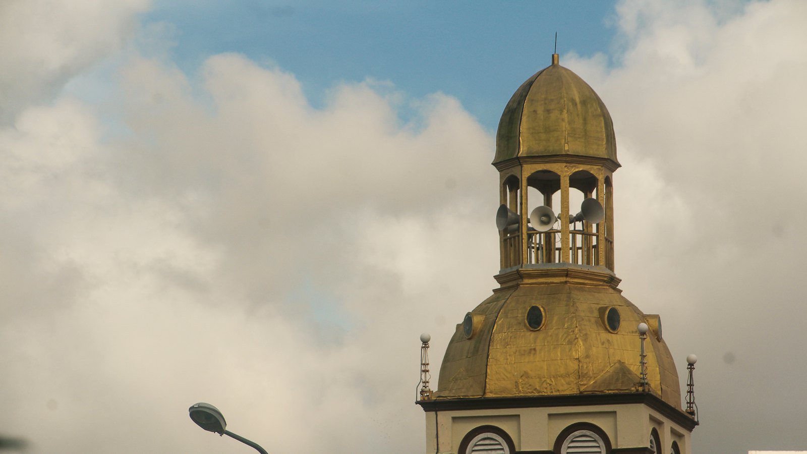 Golden dome of Masjid Muhammadi's minaret in central Kota Bharu, Kelantan, under a cloudy sky