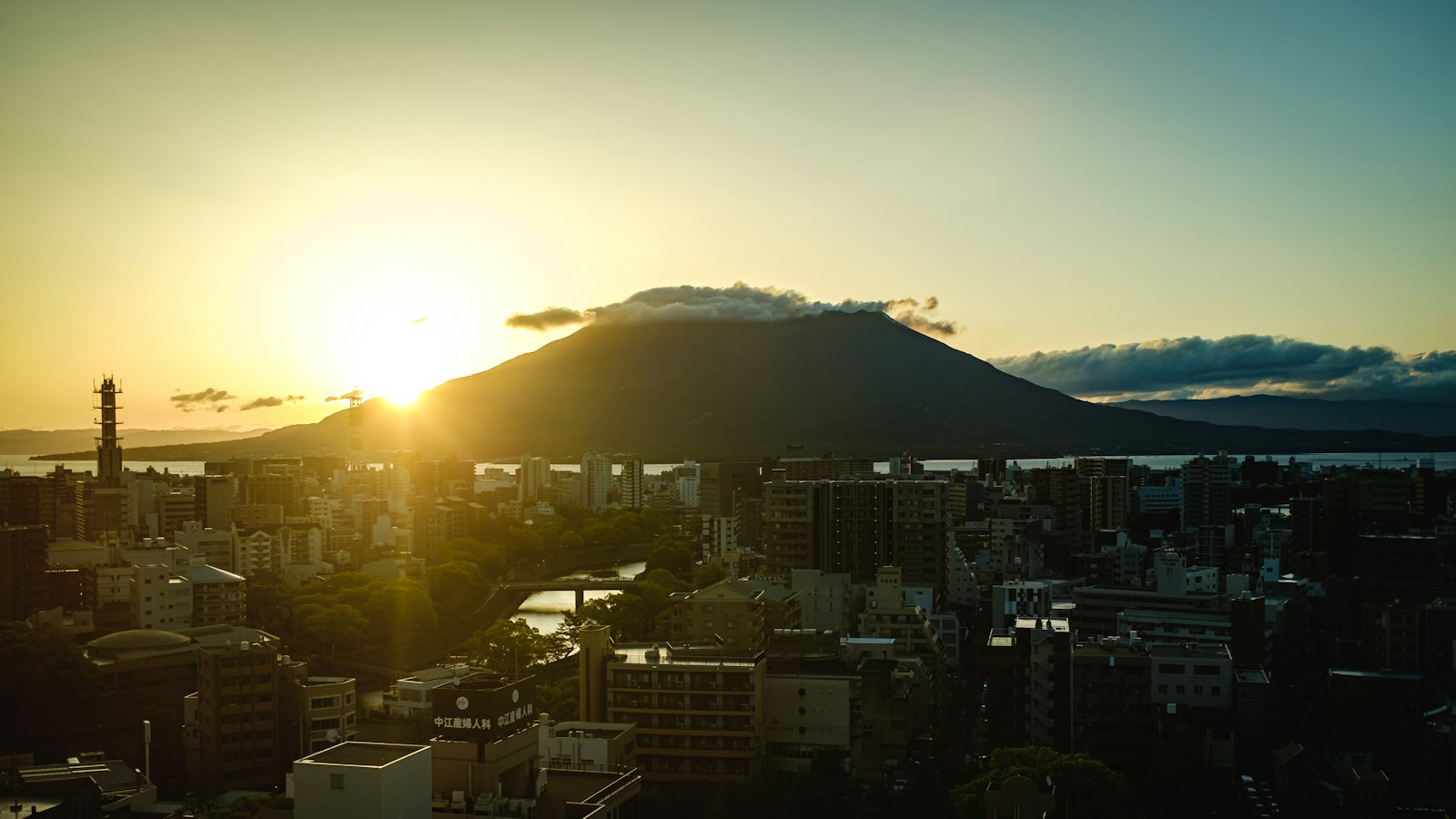Sakurajima volcano silhouetted at sunset above the city of Kagoshima