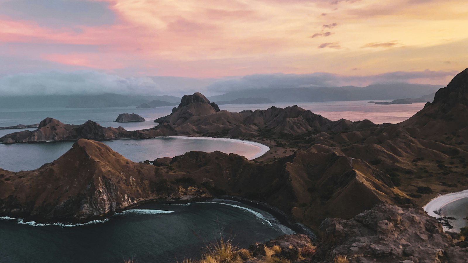 Padar Island's three curved bays and rugged peaks glowing at sunset near Labuan Bajo