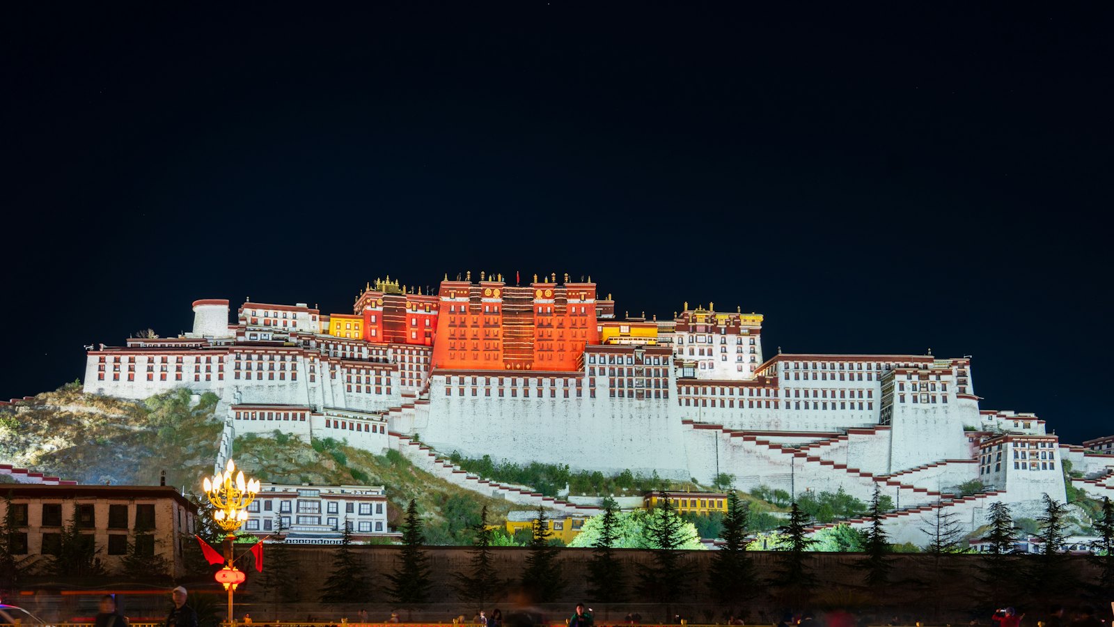 The Potala Palace illuminated at night above the city of Lhasa