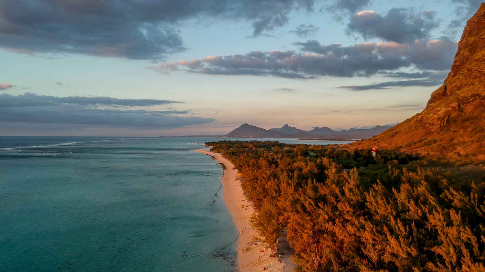 Le Morne Brabant's cliffs glowing at sunset above a turquoise lagoon in Mauritius