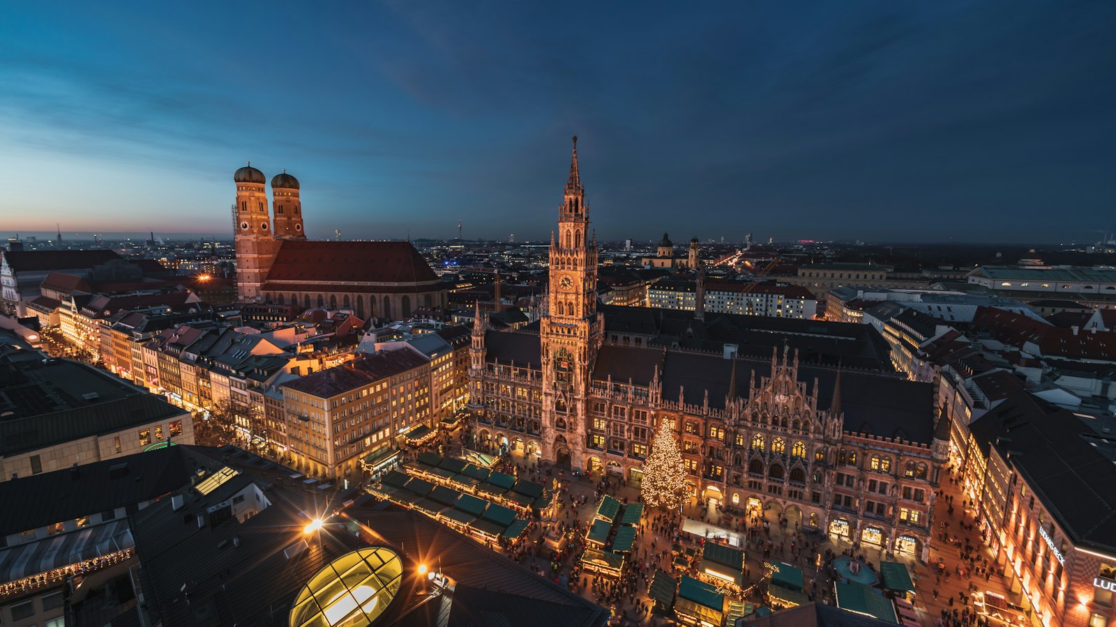 Marienplatz at blue hour with the Neues Rathaus, Frauenkirche towers and glowing Christmas market, Munich