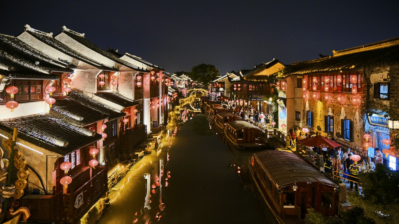 Red lanterns lighting canal houses and boats on Suzhou's Shantang Street at night