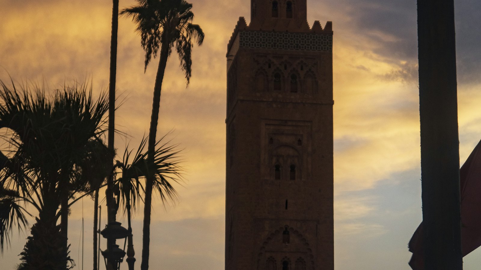 The Koutoubia Mosque minaret silhouetted against a fiery sunset sky in Marrakech