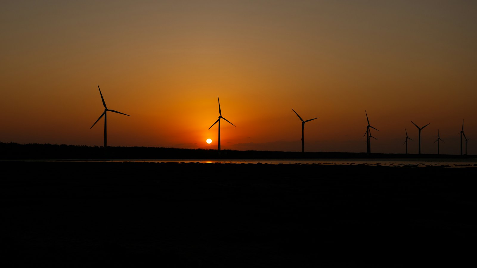 Wind turbines silhouetted against the sunset at Taichung's Gaomei Wetlands