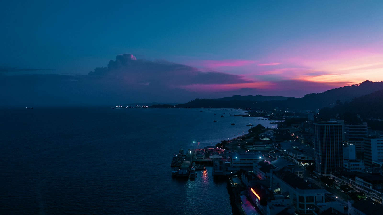 Sandakan waterfront and bay at blue hour, harbour lights under a pink Borneo sky