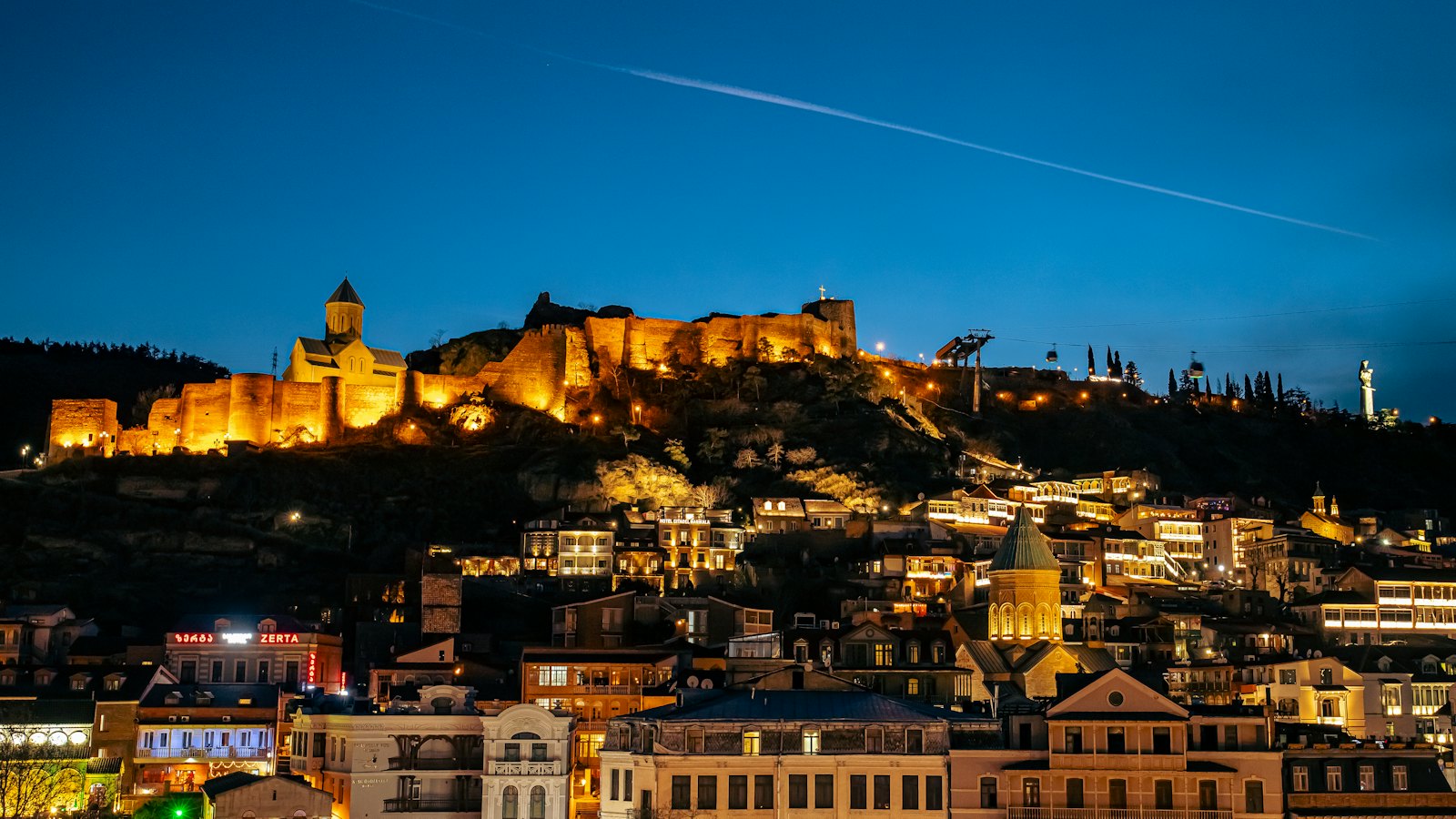 Narikala Fortress glowing above Tbilisi's illuminated old town at blue hour