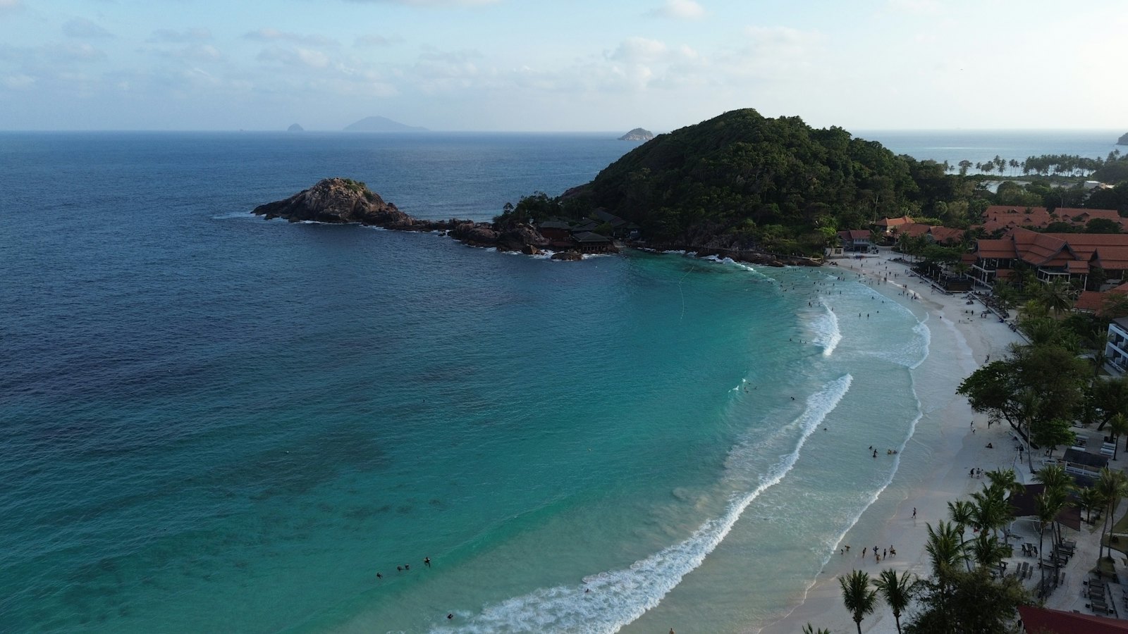 Aerial view of a turquoise bay and forested headland on Redang Island, Malaysia, at dusk