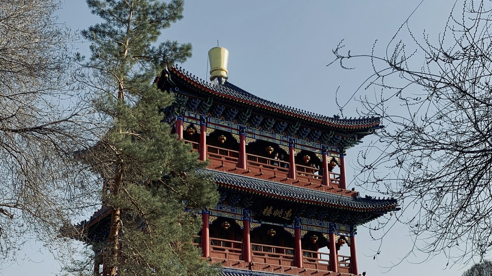 A traditional red and blue pagoda tower at dusk in an Urumqi park