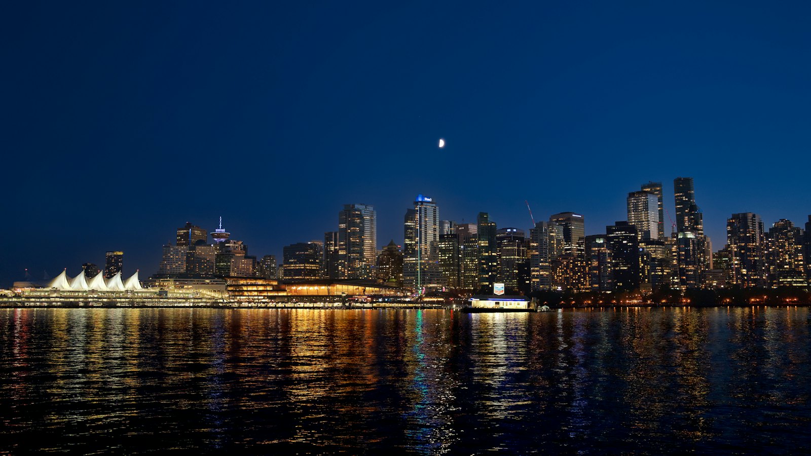 Vancouver's downtown skyline and Canada Place sails glowing across the harbour at night