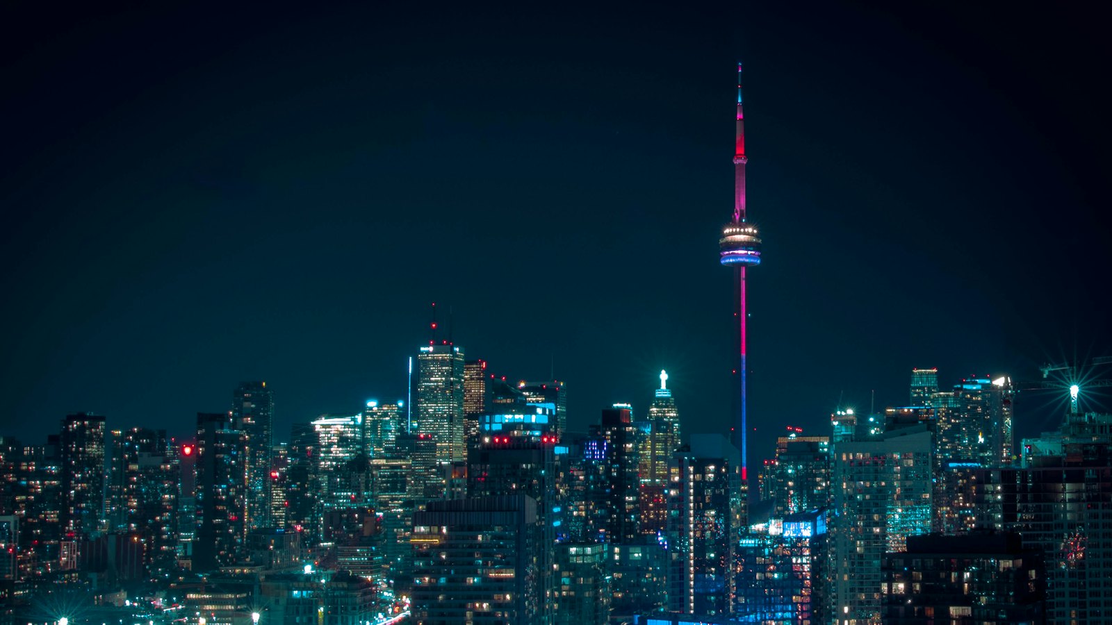The CN Tower rising above Toronto's illuminated skyline at night