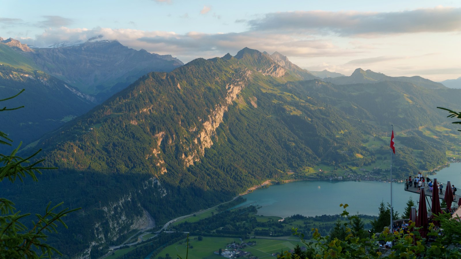 Alpine peaks framing a turquoise lake seen from above Interlaken at dusk
